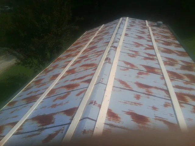 Rusted metal roof panels with new wood purlins before replacement — Storm Damage Roof Repair in Mount Clare by Roofing Brothers