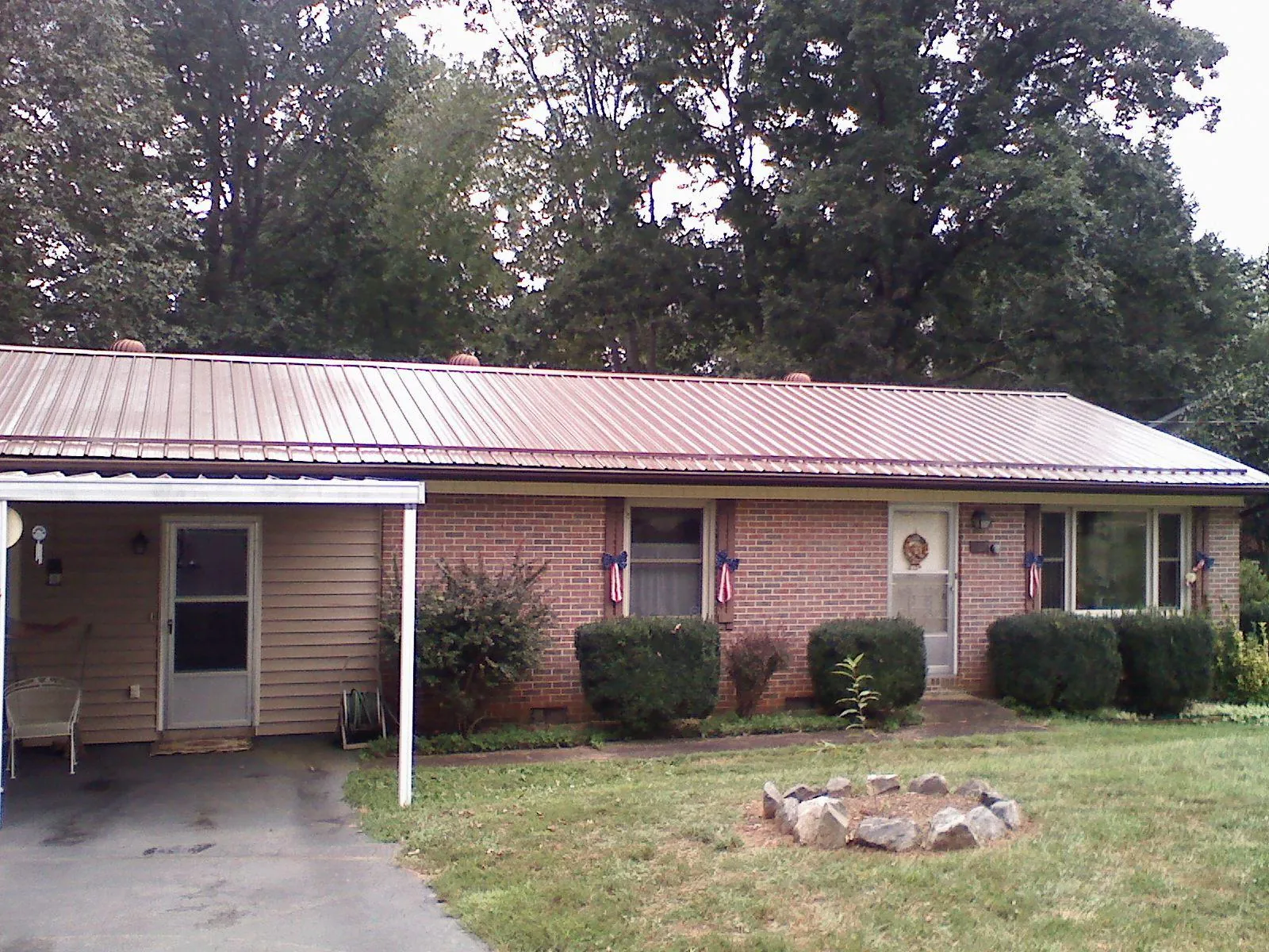 Bronze metal roof and carport on a brick ranch home — Roof Repair work by our crew in Mount Clare